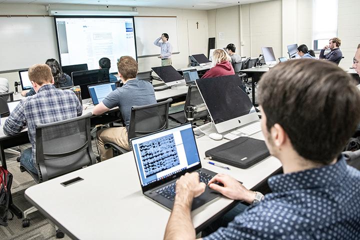 Students with laptops in computer science classroom